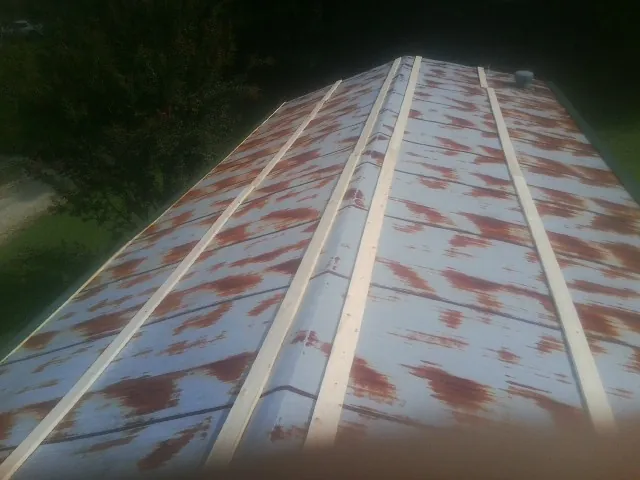 Rusted metal roof panels with new wood purlins before replacement — Storm Damage Roof Repair in Post by Roofing Brothers